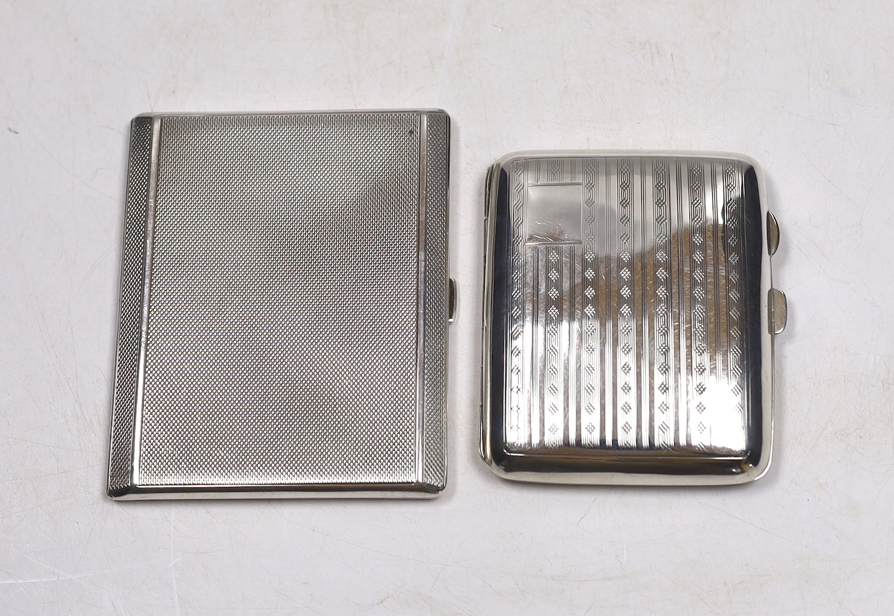A George V engine turned silver cigarette case, Birmingham, 1935, 10.2cm and one other earlier silver cigarette case.